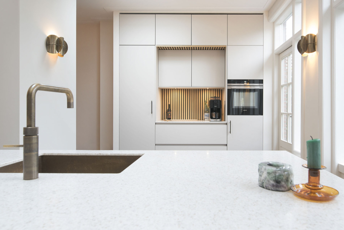 Heemstede-Robuuste witte keuken met houten elementen en stenen blad