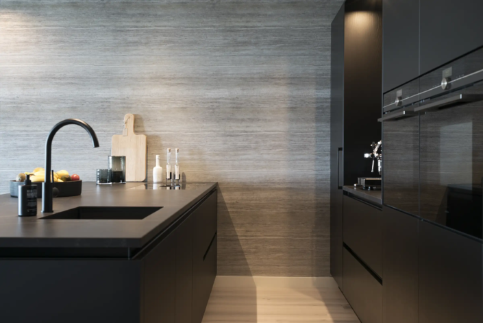 Zwarte moderne keuken met grijze horizontale streperige achterwand