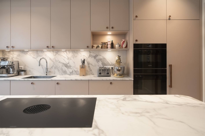 Design keuken met hoge kastenwand en ge&iuml;ntegreerde apparatuur