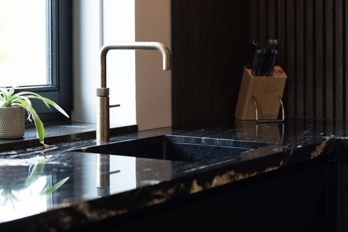 Marmeren kookeiland in luxe zwarte maatwerkkeuken