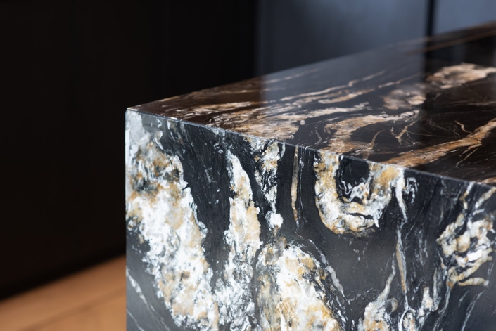 Zwarte designkeuken met marmeren werkblad en kookeiland