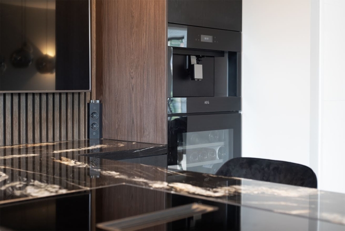 Luxe maatwerkkeuken met donker front en opvallend marmeren eiland