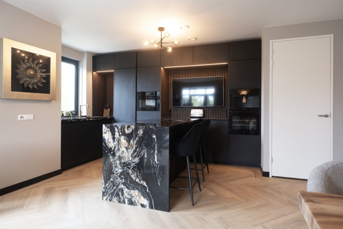 Luxe zwarte maatwerkkeuken met marmeren kookeiland