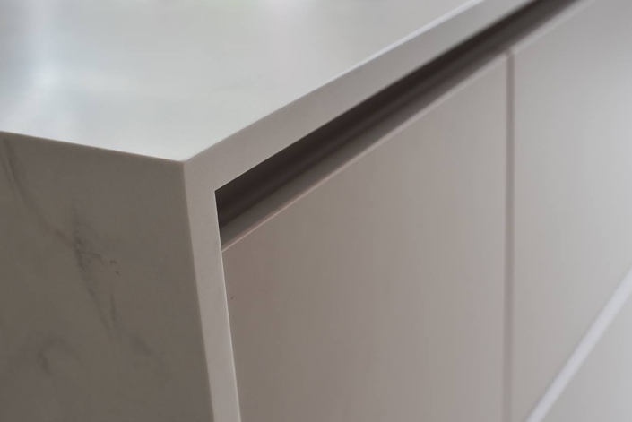 Detail van strak keukenfront met subtiele greeplijst